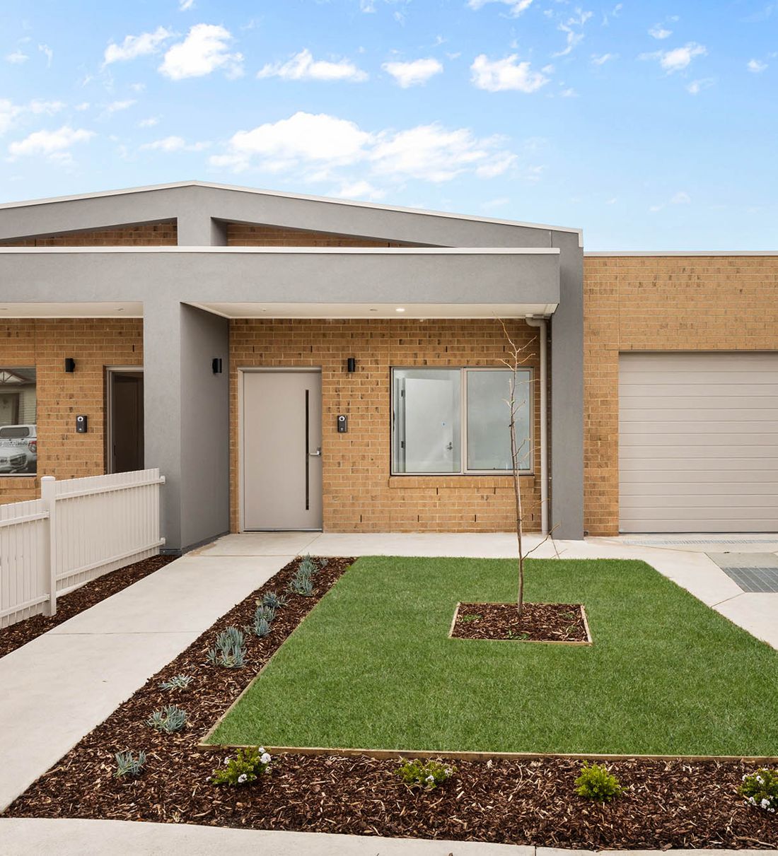 Gillies House: a single-storey brick home with a white picket fence and front lawn, Fairfield